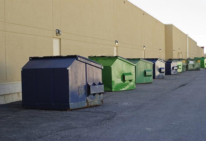 a group of dumpsters lined up along the street ready for use in a large-scale construction project in Bellmawr